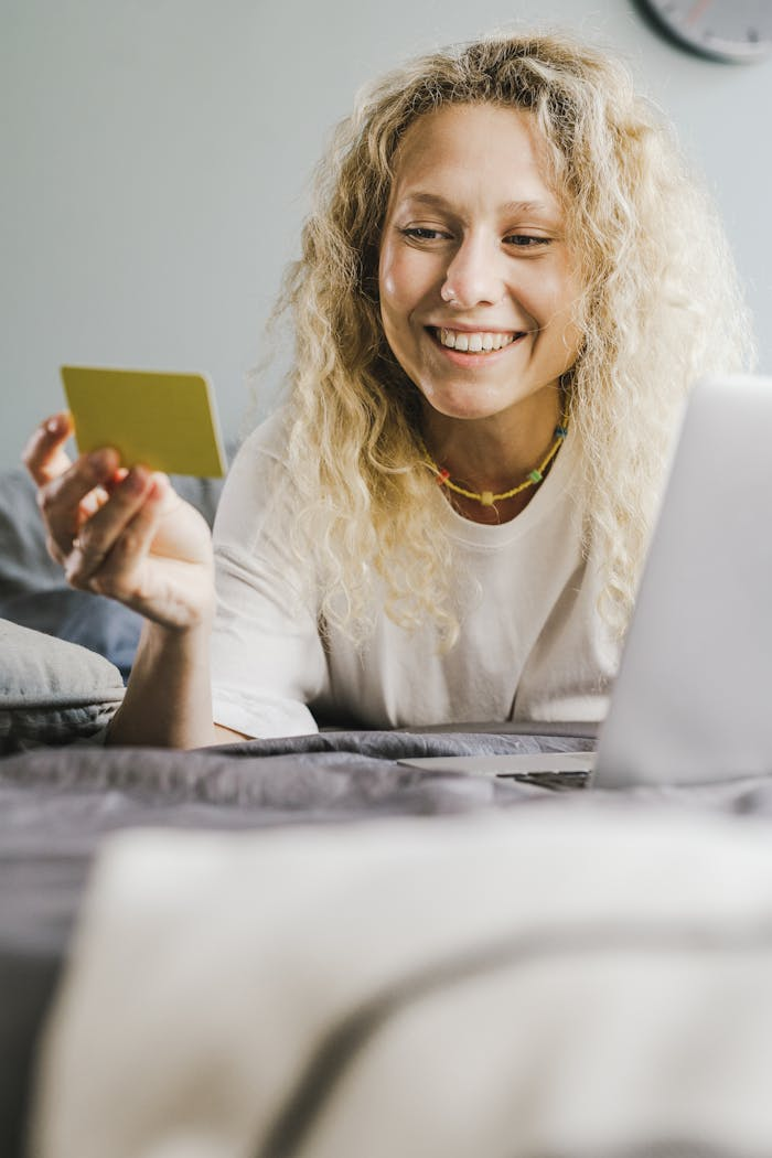 Smiling Woman in White Shirt Lying on Stomach Holding a Yellow Card